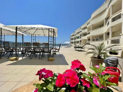 a hotel patio with tables and chairs and flowers at Апартаменти Сънбрийз - Sunbreeze Apartments in Byala