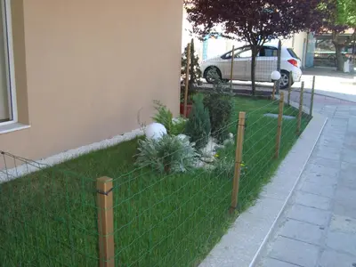 a fence in front of a yard with plants at Hotel Astra in Ravda