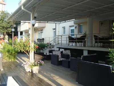 a patio with chairs and tables on a building at Hotel Astra in Ravda