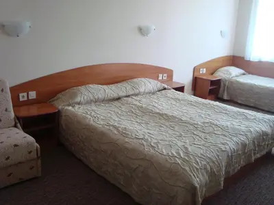 a hotel room with a bed and a chair at Hotel Astra in Ravda