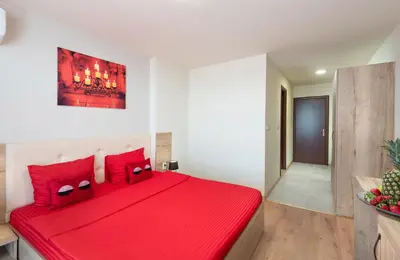 a red bed in a white room with red pillows at Sea View Hills in Sveti Vlas