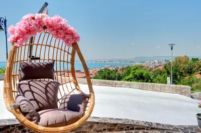 a wicker chair with pink flowers in a basket at Sea View Hills in Sveti Vlas