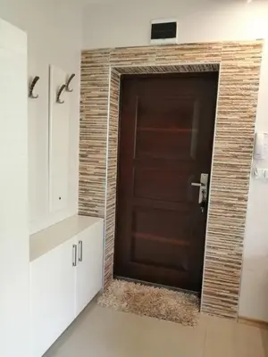 a brown door in a white room with a counter at Apartament Peyo Yavorov in Burgas City