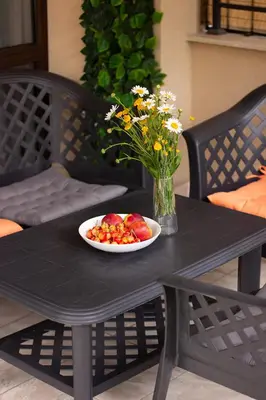 a table with a plate of fruit and a vase of flowers at Vera by RV Apartments in Varna City