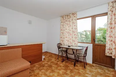 a living room with a table and chairs and a window at Guest House Galema in Obzor
