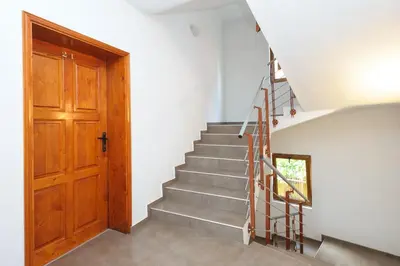 a staircase in a house with a wooden door at Guest House Galema in Obzor