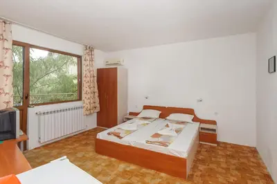 a bedroom with a bed and a large window at Guest House Galema in Obzor