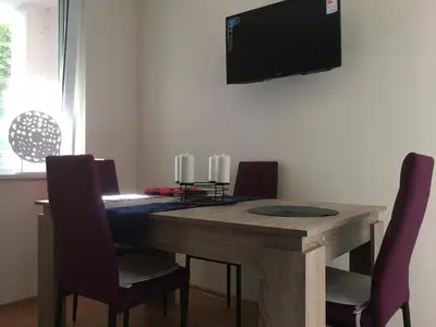 a dining room table with chairs and a television on the wall at Apartment in Nessebar Fort Club in Sunny Beach