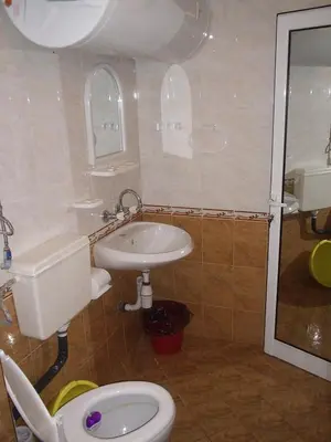 a bathroom with a white toilet and a sink at Familia Fantastiko in Kiten