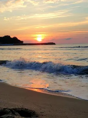 a sunset on a beach with the ocean at Familia Fantastiko in Kiten
