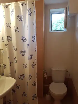 a bathroom with a toilet and a shower curtain at Apartment Zora in Sozopol