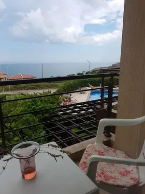 a balcony with a table and chairs and a swimming pool at Apartment Zora in Sozopol