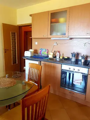 a kitchen with a table and a stove and a sink at Apartment Zora in Sozopol