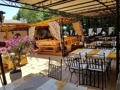 a restaurant with tables and chairs under a pavilion at Family Hotel Kedara in Burgas City