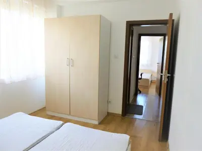 a bedroom with a bed and a cabinet and a mirror at Apartment Lozenets in Lozenets