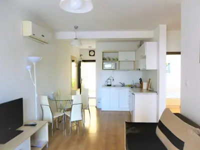 a living room and kitchen with a table and chairs at Apartment Lozenets in Lozenets