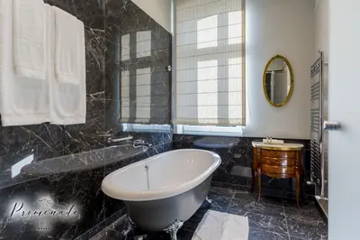 a bathroom with a white tub and a sink at Villa Promenade in Burgas City