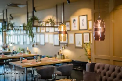 a restaurant with tables and chairs and pendant lights at Villa Promenade in Burgas City