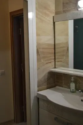 a bathroom with a sink and a mirror at Apartment Aquamarine in Burgas City