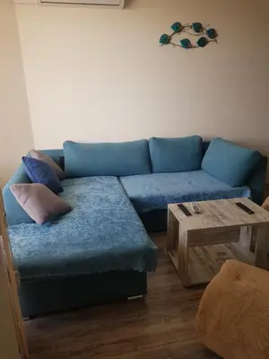 a living room with a blue couch and a wooden table at Apartment Aquamarine in Burgas City