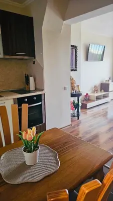 a dining room table with a vase of flowers on it at Apartment 7 and Studio 2 Quietly and peaceful place to relax in Sozopol