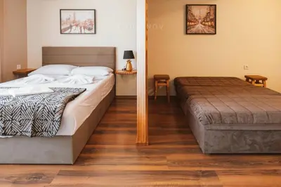 a bedroom with a large bed and a wooden floor at Apartment 7 and Studio 2 Quietly and peaceful place to relax in Sozopol
