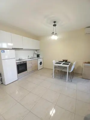 a kitchen with a table and a white refrigerator at Star Dreams, Sveti Vlas in Sveti Vlas