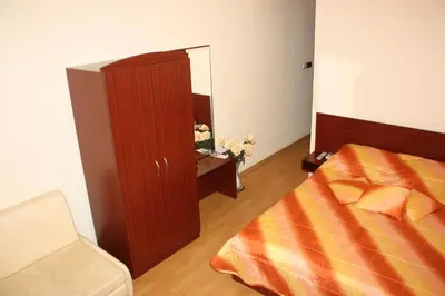 a bedroom with a bed and a cabinet and a mirror at Style Place in Kiten