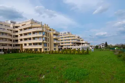 a large apartment building with a green field in front of it at Apartment EliMar in Burgas City