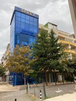 a blue building with a tree in front of it at Квартира у моря in Pomorie