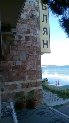 a sign on the side of a building next to the beach at Hotel Blian in Ravda