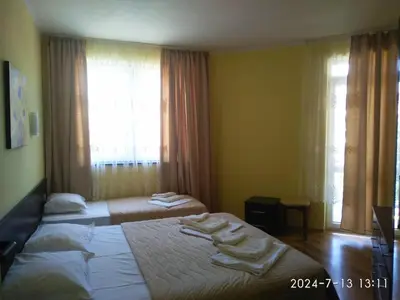 a hotel room with two beds and a window at Central Plaza Apartment in Sunny Beach