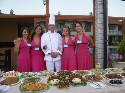a group of people standing next to a table with food at Triumph Holiday Village in Sveti Vlas