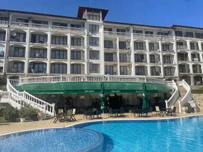 a hotel with a swimming pool in front of a building at Triumph Holiday Village in Sveti Vlas