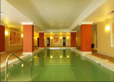 a swimming pool in a hotel with red columns at Къща за гости Мускат 2 in Aheloy