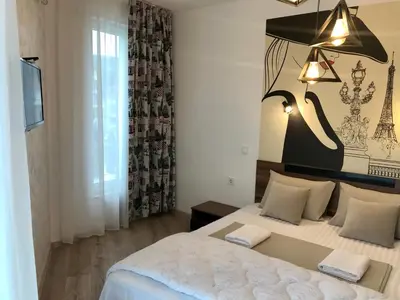 a bedroom with a large bed and a large window at Apartment RAYA in Obzor