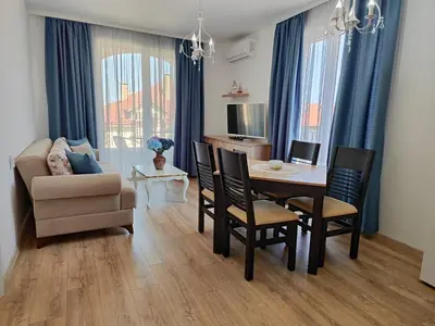 a living room with a table and chairs and a couch at Apartment RAYA in Obzor
