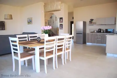 a kitchen and dining room with a table and chairs at Coral Luxury Villas in Lozenets