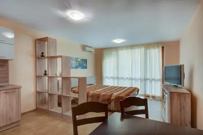 a small room with a bed and a television at ДриймБг Апартаменти - Панорама Бийч, Несебър in Nesebar