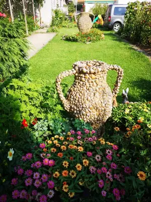 a large vase sitting in a garden of flowers at Anele,Kiten in Kiten