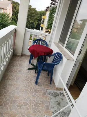a porch with two blue chairs and a table on it at Anele,Kiten in Kiten
