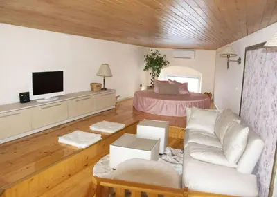 a living room with a couch and a tv at Нестандартно Бутиково студио за двама Романтика in Varna City