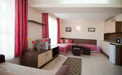 a living room with two beds and a kitchen at Hotel Radis in Kiten