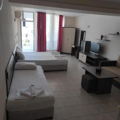 a large living room with two beds and a tv at Hotel Radis in Kiten