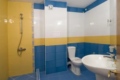 a bathroom with a toilet and a sink and a shower at Hotel Radis in Kiten