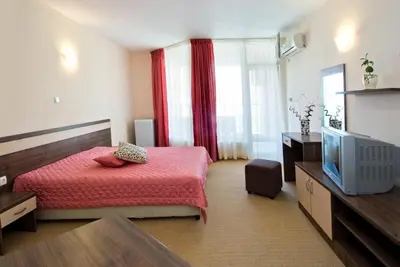 a bedroom with a red bed and a television at Hotel Radis in Kiten