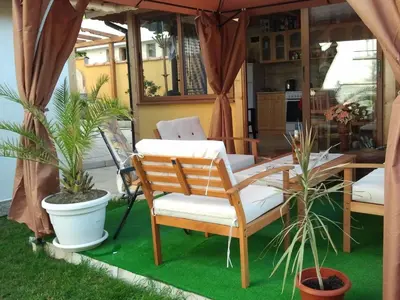 a porch with a couple of chairs and plants at Vila Riviera in Chernomorets