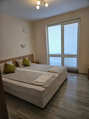 a bedroom with a large bed with a large window at Апартаменти Кастро/Castro Apartments in Tsarevo
