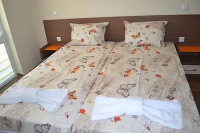 a bed with two bow ties on it at Апартаменти Кастро/Castro Apartments in Tsarevo
