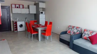 a living room with a table and chairs and a couch at Апартаменти Кастро/Castro Apartments in Tsarevo